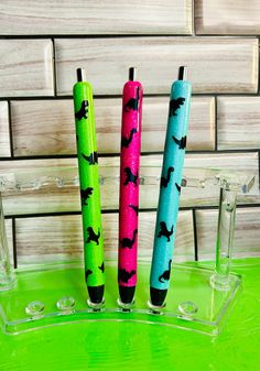 three pens sitting on top of a green table