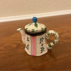 a ceramic tea pot sitting on top of a wooden table