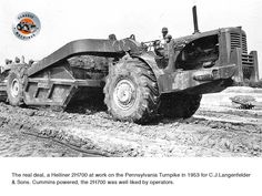 an old black and white photo of a large tractor in the middle of a dirt field