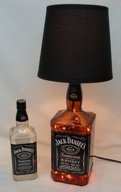 a lamp that is on top of a table next to a bottle of jack daniels