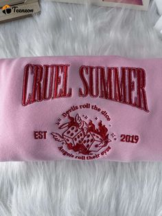 a pink towel with the word cruel summer on it and some other items around it