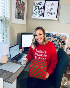 a woman sitting in an office chair holding a christmas present with the words santa's favorite reader on it