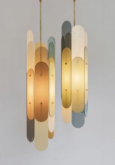 three circular lights hanging from the ceiling in an art deco style with different colors and shapes