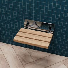 a wooden shelf mounted to the side of a blue tiled wall next to a tile floor