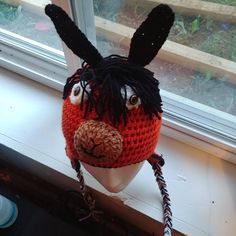 a knitted animal head sitting on top of a window sill