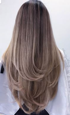 the back of a woman's head with long, blonde hair in front of her