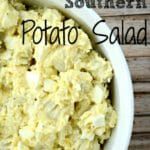 a bowl filled with potato salad on top of a wooden table