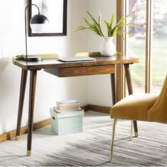 a desk with a lamp, chair and books on it in front of a window