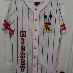 Disney Mickey Mouse White Piping Strips Jersey Shirt Small Mickey Mouse Baseball Jersey Shirt, Disney Baseball Jersey The Classic Baseball Design With Mesh Material And Button-Down Front, Piping Strips Adds An Extra Touch Of Retro Charm. Color: White, Red, Front & Back Printed Mickey Mouse Fabric Type: 100% Polyester Care Instructions: Machine Wash Closure Type: Red Buttons 30” L X 22” Armpit To Armpit Brand New With A Defect **It Has A Small Tear In The Front** Mickey Mouse Fabric, Baseball Jersey Shirt, Baseball Design, Disney Tops, Red Button, Mesh Material, Piping, Jersey Shirt, Disney Mickey Mouse