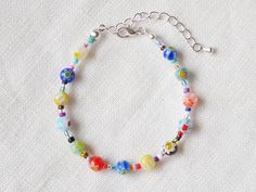 This millefiori glass bead bracelet is colorful and cute. In this silver- or gold-plated bracelet, I have paired colorful millefiori glass beads with tiny glass seed beads. The beading wire I use is high-quality stainless steel, composed of multiple twisted tiny wires that are nylon coated to protect the beads. This bracelet adds color to any outfit and is both laid-back and cool at the same time - you can easily wear this every day if you like.  The bracelet comes with an extension chain so you can adjust the length of the bracelet between 6.5 inches and 8 inches. The extension chain looks nice and it makes it much easier to put on the bracelet. Each bracelet is a unique piece made to order - the order and the selection of beads may vary. Want a matching necklace? You can find it here: ht Colorful Beaded Chain Bracelets As Gift, Multicolor Glass Beaded Bracelets With Polished Beads, Multicolor Glass Beaded Bracelets With Beaded Chain, Silver Bracelet With Colorful Glass Beads, Multicolor Flower Bracelets With Tiny Beads, Multicolor Czech Glass Beaded Chain Bracelets, Multicolor Flower Bracelets With Spacer Beads, Multicolor Glass Beaded Chain Bracelets, Multicolor Flower Shaped Beaded Bracelet