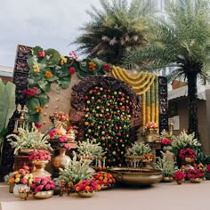 there are many vases with flowers on the side of the wall and in front of them is a fountain