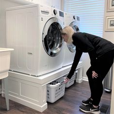 a woman standing in front of a washing machine