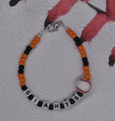 an orange and black beaded bracelet with the word giants written in white letters on it