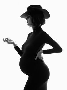 a pregnant woman wearing a hat and dress