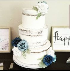 a three tiered white cake with blue flowers on top