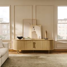 a living room scene with focus on the sideboard and large window in the background