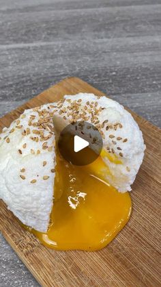 a piece of cake on a cutting board with an egg in the middle and sesame sprinkles around it