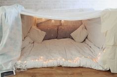 a bed that has been made into a tent with lights on the inside and outside