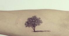 a small tree tattoo on the left arm