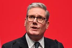 a man wearing glasses speaking at a podium