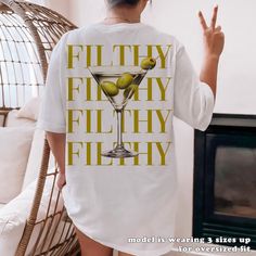 "Indulge in the sophisticated allure of our Filthy Martini Sweatshirt--a perfect gift for yourself or Dirty Martini lover in your life. This Martini Cocktail Pullover, with its preppy crewneck style, is the ultimate 'Tini Time' sweater, making it a delightful and stylish gift for her, whether she's your wife, girlfriend or simply a cherished friend. - Unisex Fit -  Our shirts are super soft and comfy with a regular unisex fit. Want that extra oversized feel? Just check out the sizing chart image and go up 2-3 sizes for the perfect laid-back look! -Perfect Shirts for Perfect Adventures- - Classic Unisex Fit - Runs true to size: Please see the size chart in each listing for more details. - 100% Airlume combed and ring-spun cotton for all regular colors - 52% Airlume combed and ring-spun cott Birthday Themes For Women Decoration, Martini And Matrimony Bachelorette, Party T-shirt With Letter Print In Relaxed Fit, Dirty Martini Birthday Theme, Martini Themed Bachelorette Party, Martini Bachelorette Party, Martini Birthday Party Theme, Martini Party Ideas Decoration, Martini Costume