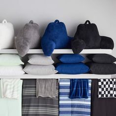 towels and pillows are lined up on a shelf