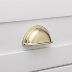 a close up of a white drawer with a brass knob on it's side