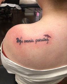 a woman with a tattoo on her shoulder that says, i'm omnia patatius