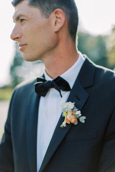 groom's boutonniere consisting of a peach ranunculus, ivory spray roses, blue delphinium, and eucalyptus Delphinium Boutonniere, Peach Boutonniere, Blue Boutonniere, Peach Ranunculus, Blue Delphinium, Roses Blue, Spray Roses, Delphinium