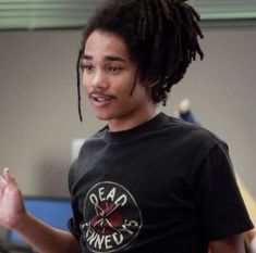 a young man with dreadlocks talking to another person