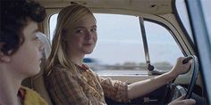 a woman sitting in the driver's seat of a car