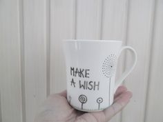 a hand holding a coffee cup with writing on it that says, make a wish