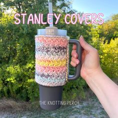 a hand holding a coffee cup with the words stanley covers on it and an image of trees in the background