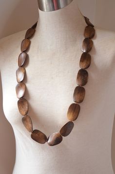 "One long strand of dark brown wood beads with glass spacer beads. The length is 37.5\" and the beads measure 1.5\" by 1\". The necklace length can be customized. The mannequin's neck size is 15\". The clasp is lead free pewter toggle. We do not recommend double wrapping this necklace. If you would like a multi strand version or other colors: www.etsy.com/shop/DanaLeBlancDesigns?ref=seller-platform-mcnav&search_query=miranda+wood All DLD jewelry comes in a silver jewelry box for gift giving. Rustic Brown Wooden Beaded Necklaces, Rustic Brown Wooden Beads Necklace, Brown Wooden Beads For Jewelry Making, Brown Wooden Beaded Jewelry, Adjustable Single Strand Brown Beads, Brown Wooden Beads Oval Jewelry, Adjustable Brown Beaded Necklaces With Oval Beads, Brown Wooden Bead Jewelry, Brown Wood Bead Jewelry