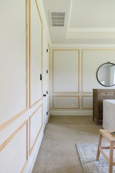 an empty room with white walls and wood trimmings on the doors, carpeted floor