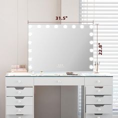 a white vanity with lights and drawers in front of a large mirror on the wall