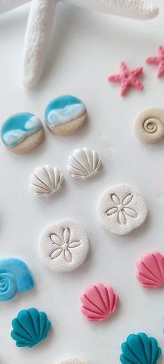 seashells and starfish on a white surface with pink, blue, and green icing