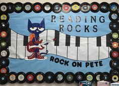 a bulletin board with an image of a cat playing the piano and reading rocks on it