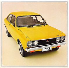 an old yellow car is parked on the floor in front of a white wall and beige background