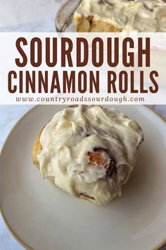 a close up of a doughnut on a plate with the words sourdough cinnamon rolls