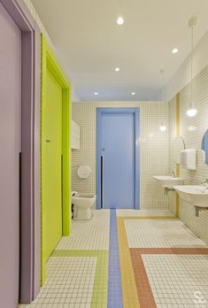 a bathroom with multicolored tile floors and walls, along with a blue door