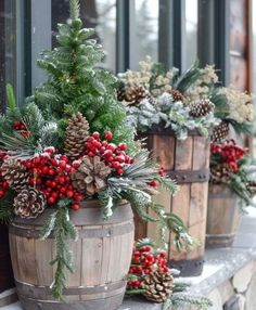 three wooden buckets filled with pine cones and red berries are sitting on a ledge