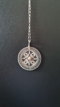 Crafted from fine silver wires reminiscent of lace and carefully crafted by hand into an elegant design with delicate swirls that meet in the middle to form a dainty flower. It comes with a sterling silver 57 cm (22.5'') chain. The necklace weighs 6g, pendant has a diameter of 3.3cm there is a glue-like small smudge, but other than that in excellent condition. Filigree, the delicate and intricate metalwork of fine wires and beads, is a hallmark of Bulgarian silver craftsmanship. Filigree is ofte Elegant Metal Necklaces With Flower Shape, Elegant Spiral Jewelry For Gifts, Elegant Spiral Filigree Jewelry, Delicate Sterling Silver Necklace, Spiral Jewelry With Intricate Design For Gift, Nickel-free Sterling Silver Elegant Necklace, Elegant Sterling Silver Nickel-free Necklace, Elegant Nickel-free Sterling Silver Necklace, Delicate White Gold Jewelry With Intricate Design