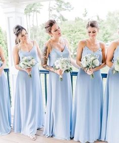 the bridesmaids are all dressed in light blue dresses and holding their bouquets