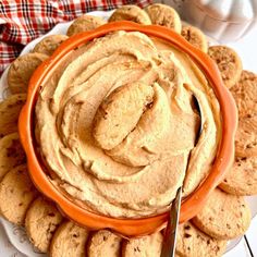 a plate full of cookies and hummus with a fork in the bowl next to it