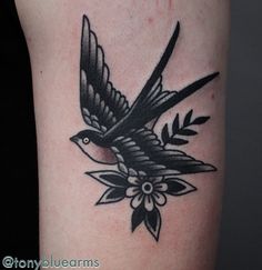 a black and white bird tattoo on the arm