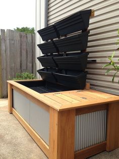 a wooden bench with several black containers in it