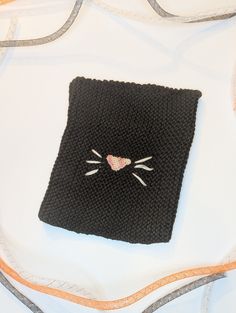 This kids hat was made with black baby yarn so it is incredibly soft! A pink nose was crocheted and sewed on the front along with 6 white whiskers. It is 6.5 inches wide and 8 inches tall. There is moderate stretch allowance to fit many sizes. Any questions please ask! Black Novelty Beanie One Size Fits Most, Novelty Black Beanie, One Size Fits Most, Playful Handmade Black Hats, Black Novelty Beanie, Cute Black Crochet Hat For Winter, Black Hand Knitted Beanie One Size, Black One Size Cat Ears Hat, Black One Size Crochet Knit Hat, Black Cat Ears Hat With Cat Design