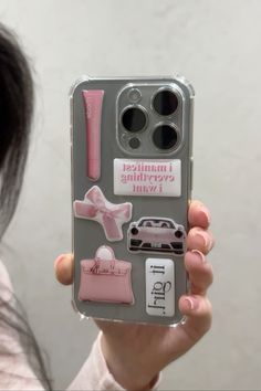 a person holding up a cell phone case with stickers on it