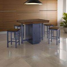 a kitchen with an island and stools next to a potted plant on the floor